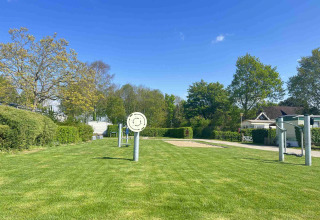 Prato verde con strutture ricreative e alberi al Vakantiepark de Zeeuwse Parel in Zelanda, Paesi Bassi.