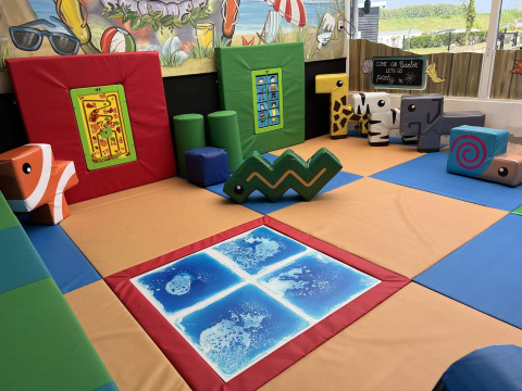 Zona de juegos infantil cubierta con bloques y colchonetas de colores en Vakantiepark de Zeeuwse Parel.