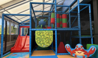 Parco giochi al coperto di Vakantiepark de Zeeuwse Parel con scivolo rosso, struttura e simpatico granchio.
