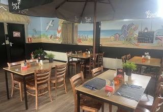 Ristorante interno al Vakantiepark de Zeeuwse Parel, Zelanda, Paesi Bassi, con murale a tema spiaggia.