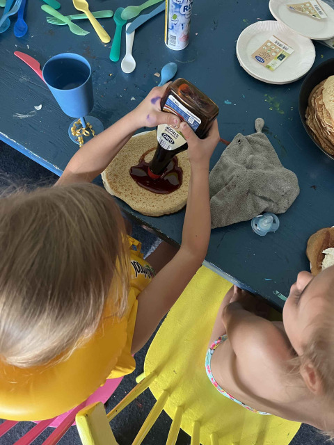 Dos niños preparan panqueques en una mesa con utensilios coloridos en el parque vacacional de Zeeuwse Parel en Zelanda.