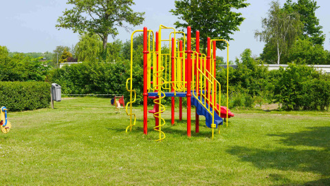 Kleurrijke speeltuin in Vakantiepark de Zeeuwse Parel, een vakantiepark in Zeeland, Nederland, met veel groen.