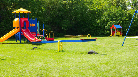 Bunter Kinderspielplatz mit Rutschen und Wippen im Ferienpark de Zeeuwse Parel in Zeeland, Niederlande.
