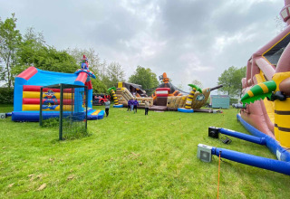 Hüpfburgen im Freien auf grüner Wiese im Vakantiepark de Zeeuwse Parel, Zeeland, Niederlande.