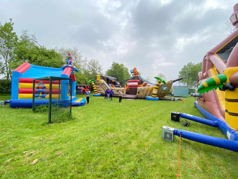 Hüpfburgen im Freien auf grüner Wiese im Vakantiepark de Zeeuwse Parel, Zeeland, Niederlande.