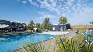 Piscina al aire libre y zona de relax en Vakantiepark de Zeeuwse Parel en Zelanda, Países Bajos.