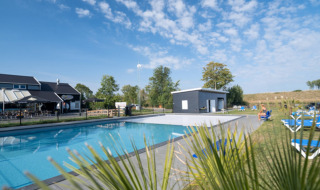 Piscina al aire libre y zona de relax en Vakantiepark de Zeeuwse Parel en Zelanda, Países Bajos.