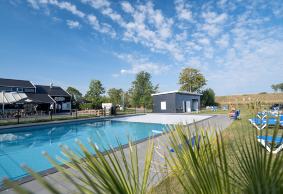 Udendørs swimmingpool og afslapningsområde hos Vakantiepark de Zeeuwse Parel i Zeeland, Holland.