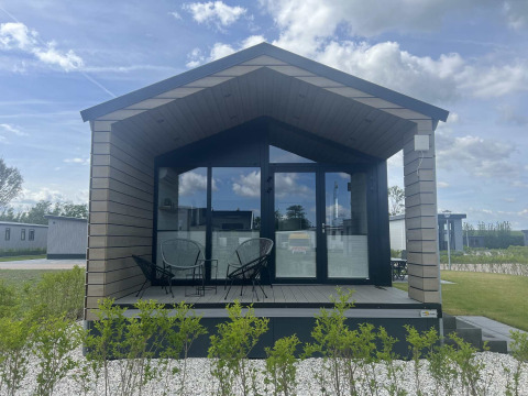 Modern lodge at De Parel, Vakantiepark de Zeeuwse Parel in the Netherlands, featuring a glass facade.