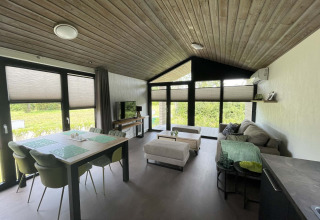 Moderne lodge op De Parel, Vakantiepark de Zeeuwse Parel, Nederland, met ruime woonkamer en grote ramen.