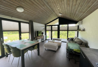Moderne lodge på De Parel, Vakantiepark de Zeeuwse Parel, Holland, med åbent opholdsrum og store vinduer.