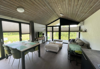 Moderne lodge på De Parel, Vakantiepark de Zeeuwse Parel, Holland, med åbent opholdsrum og store vinduer.