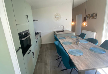 Cocina y comedor modernos en la cabaña De Schelde en Vakantiepark de Zeeuwse Parel, Países Bajos.