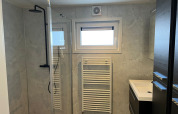 Moderne badeværelse på De Zeester-lodgen i Vakantiepark de Zeeuwse Parel, Nederlandene med brusebad og radiator.