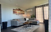 Stijlvolle woonkamer in De Zeester, Vakantiepark de Zeeuwse Parel, met grijze zetel en moderne inrichting.