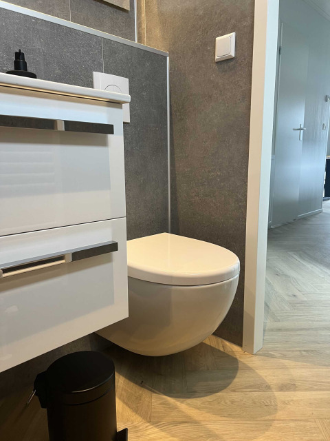 Bagno moderno con WC sospeso e mobile bianco presso Dijkzicht, Vakantiepark de Zeeuwse Parel, Paesi Bassi.