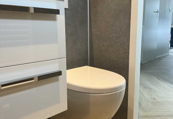 Salle de bains moderne avec toilettes suspendues et meuble blanc au Dijkzicht, Vakantiepark de Zeeuwse Parel, Pays-Bas.