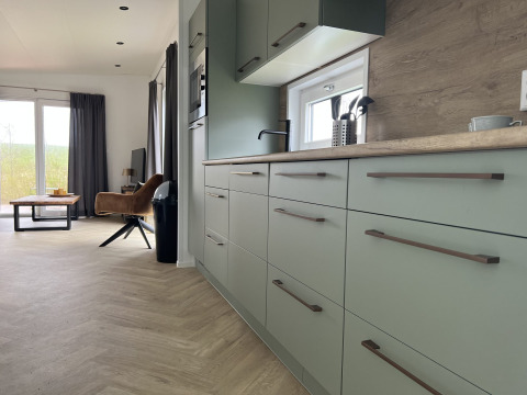 Cocina moderna y sala de estar en una cabaña en Dijkzicht, Vakantiepark de Zeeuwse Parel, Países Bajos.