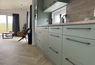 Moderne Küche und Wohnzimmer in einer Lodge bei Dijkzicht im Vakantiepark de Zeeuwse Parel, Niederlande.