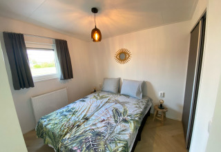 Modernes Schlafzimmer in der Dijkzicht-Lodge, Vakantiepark de Zeeuwse Parel, Niederlande, mit Doppelbett.