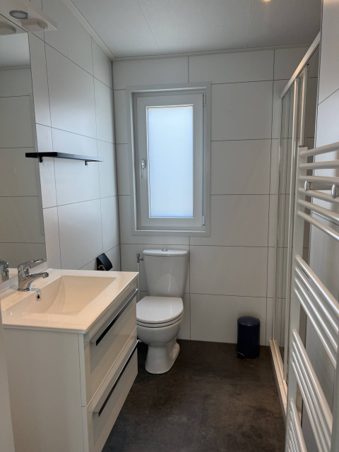 Modernes Bad mit Fenster und Dusche im Noordzee-Lodge im Vakantiepark de Zeeuwse Parel, Niederlande.