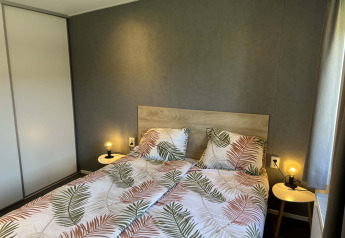 Camera da letto nella lodge Noordzee al Vakantiepark de Zeeuwse Parel, Paesi Bassi, con letto doppio.