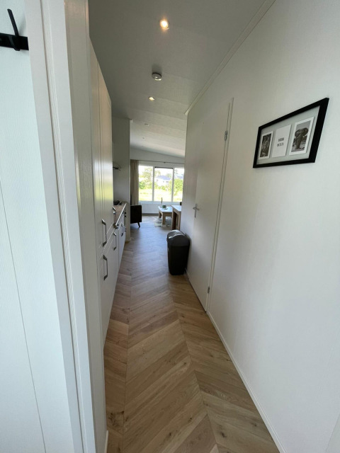 Lyst og moderne gangareal i en lodge ved Vakantiepark de Zeeuwse Parel, Noordzee, Holland, set mod stuen.