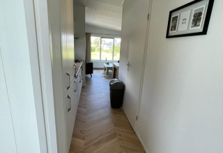 Pasillo luminoso y moderno en una cabaña de Vakantiepark de Zeeuwse Parel, Noordzee, Países Bajos, hacia la sala.