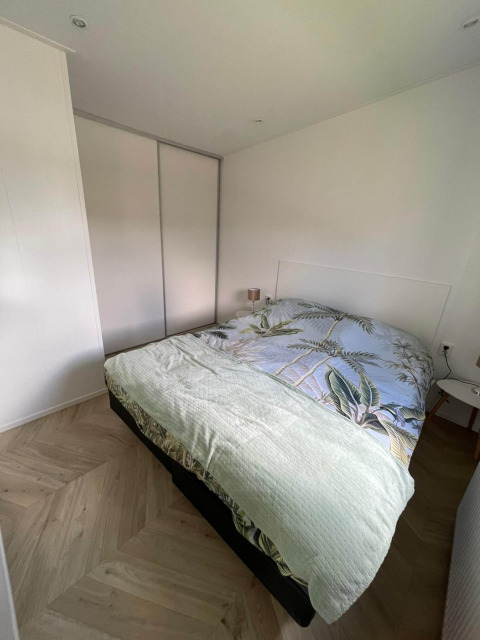 Dormitorio en la cabaña Noordzee de Vakantiepark de Zeeuwse Parel, Países Bajos, con cama y armario.