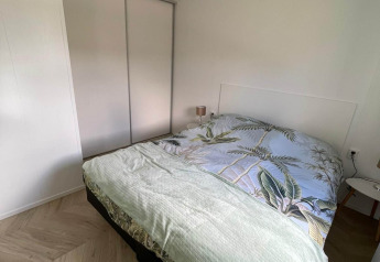 Slaapkamer in Noordzee lodge bij Vakantiepark de Zeeuwse Parel, Nederland, met bed en kledingkast.