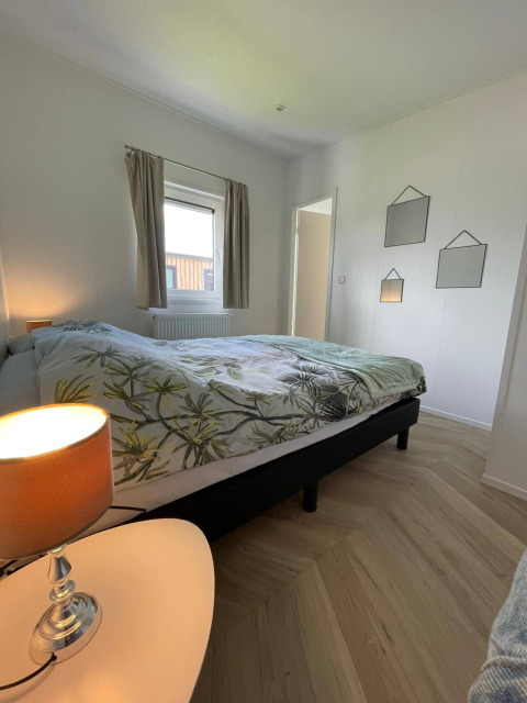 Dormitorio moderno en la lodge Noordzee del Vakantiepark de Zeeuwse Parel en los Países Bajos, con cama doble.