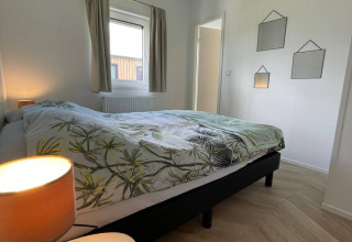 Dormitorio moderno en la lodge Noordzee del Vakantiepark de Zeeuwse Parel en los Países Bajos, con cama doble.