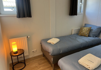 Et hyggeligt soveværelse på Parkzicht, Vakantiepark de Zeeuwse Parel, med to enkeltsenge og moderne indretning.