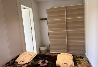 Soveværelse i Parkzicht lodge ved Vakantiepark de Zeeuwse Parel, Nederlandene, med garderobe.