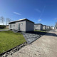 Moderne hytter på Oosterschelde lodge i Vakantiepark de Zeeuwse Parel, Holland, under blå himmel.