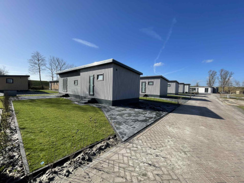 Cabañas modernas en Oosterschelde, Vakantiepark de Zeeuwse Parel, Países Bajos, bajo un cielo azul claro.