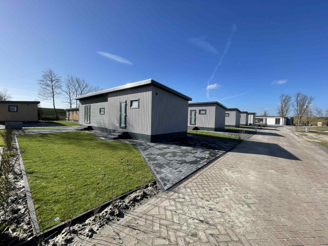 Cabañas modernas en Oosterschelde, Vakantiepark de Zeeuwse Parel, Países Bajos, bajo un cielo azul claro.