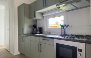 Cocina moderna en la cabaña Oosterschelde de Vakantiepark de Zeeuwse Parel, Holanda, con ventana y estufa.