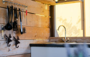 Modern kitchenette in a safari tent lodge with wood paneling, microwave, and coffee maker.