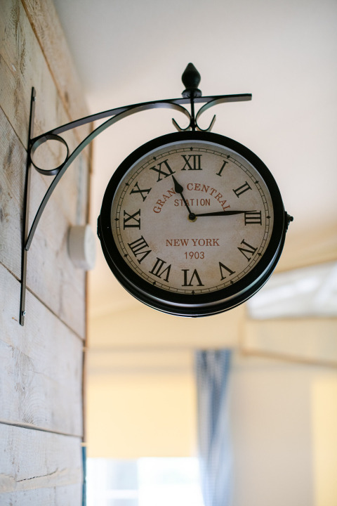 Reloj de estilo retro con números romanos colgado en la pared de una tienda safari en Tentlodge.