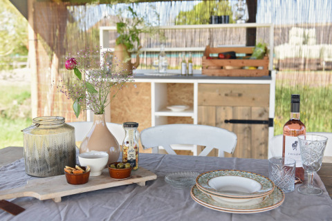 Table en plein air avec vin, fleurs et vaisselle à Smûk Lytse Bell Tent, Smûk Recreatie, Pays-Bas.