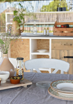 Table en plein air avec vin, fleurs et vaisselle à Smûk Lytse Bell Tent, Smûk Recreatie, Pays-Bas.