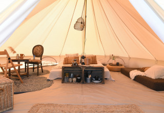Gemütliches Glamping-Zelt mit Bett, Sitzbereich und Dekoration im Smûk Recreatie, Friesland, Niederlande.