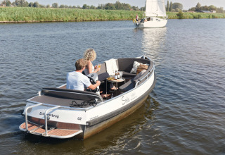 Zwei Personen entspannen auf einem Boot bei Smûk Lytse Bell Tent, Smûk Recreatie, Niederlande.