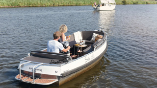 Deux personnes profitant d'un bateau près de Smûk Lytse Bell Tent chez Smûk Recreatie aux Pays-Bas.