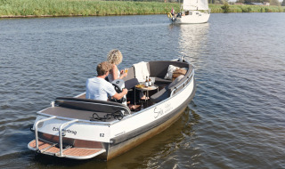 Deux personnes profitant d'un bateau près de Smûk Lytse Bell Tent chez Smûk Recreatie aux Pays-Bas.