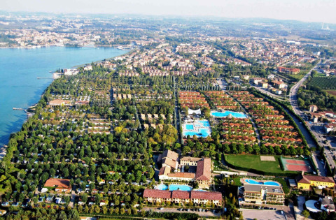 Vista aerea del Camping Bella Italia, parco vacanze a Peschiera del Garda, Veneto, Italia, tra piscine e verde.