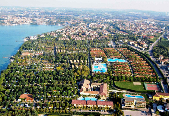 Vista aerea del Camping Bella Italia, parco vacanze a Peschiera del Garda, Veneto, Italia, tra piscine e verde.