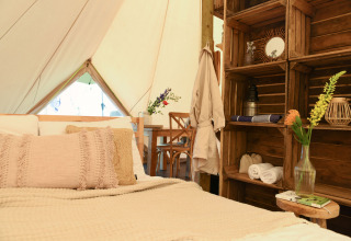 Indretning af hyggelig safari telt Smûk Grutte Bell Tent med bløde puder, hylder og blomster, Smûk Recreatie.