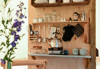 Køkkenhjørne i safari teltet Smûk Grutte Bell Tent hos Smûk Recreatie i Holland med tepotte og køkkenredskaber.